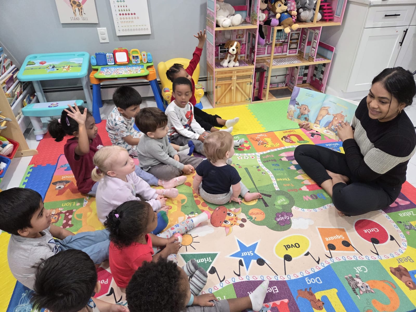 Children raising hands during story time at Nurture and Grow